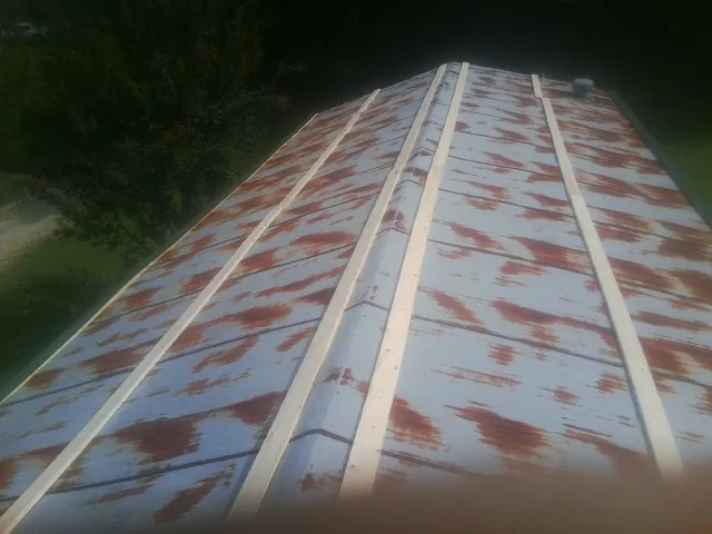 Rusted metal roof panels with new wood purlins before replacement — Storm Damage Roof Repair in Tooele by Roofing Brothers