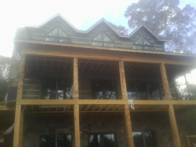 Dormers and porch framing on a large log home under construction — Roof Coating work by our crew in Tooele