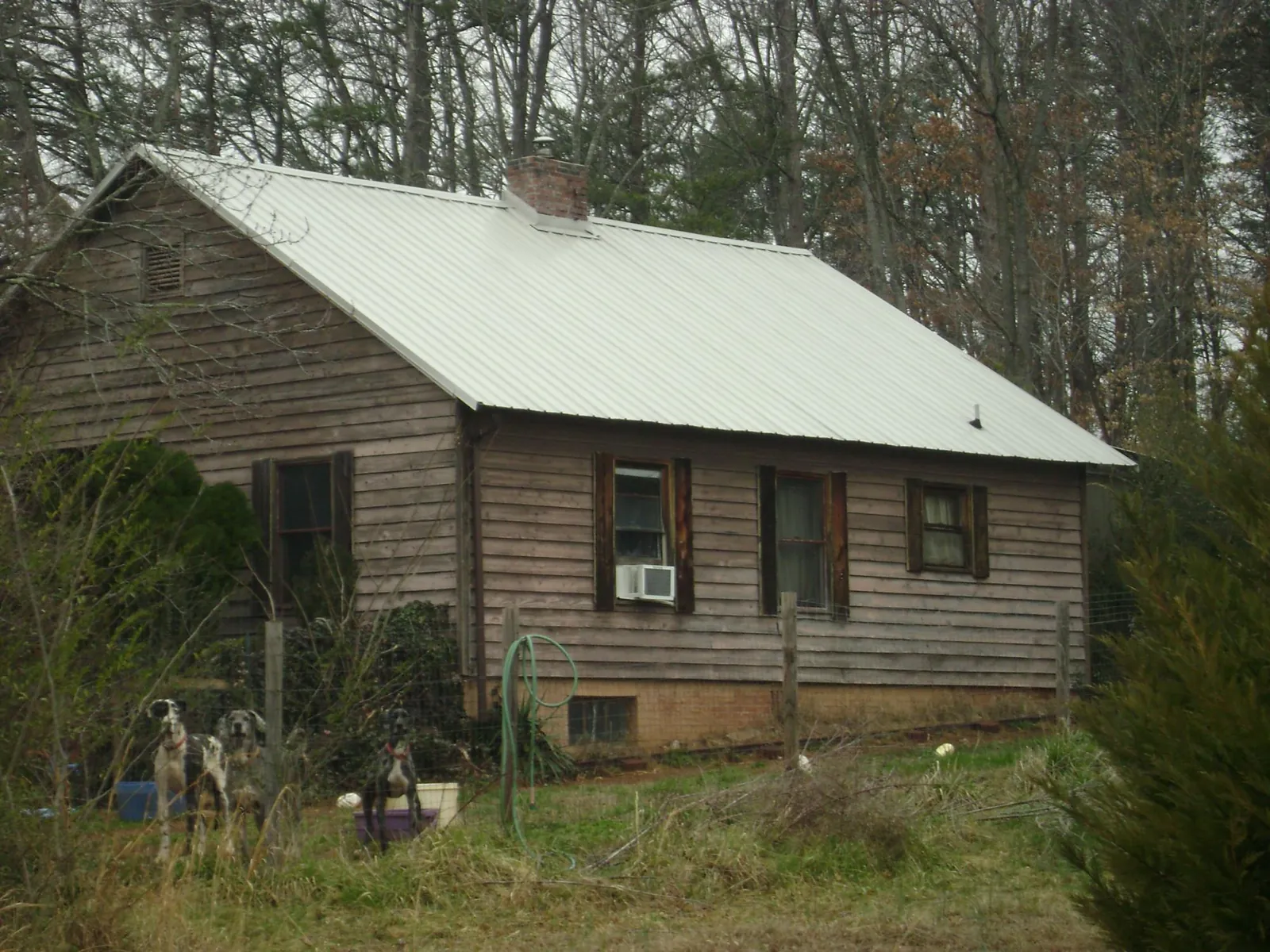 White metal roof on an old wood sided farmhouse, from a Metal Roof Installation job in Tooele
